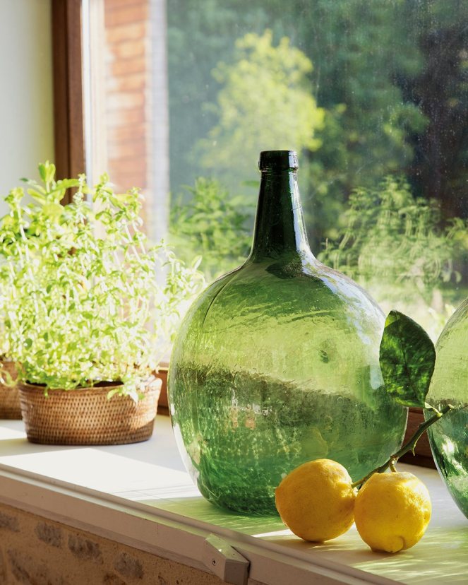 detalle_de_botella_de_cristal_planta_y_limones_sobre_repisa_de_la_ventana_1024x1280